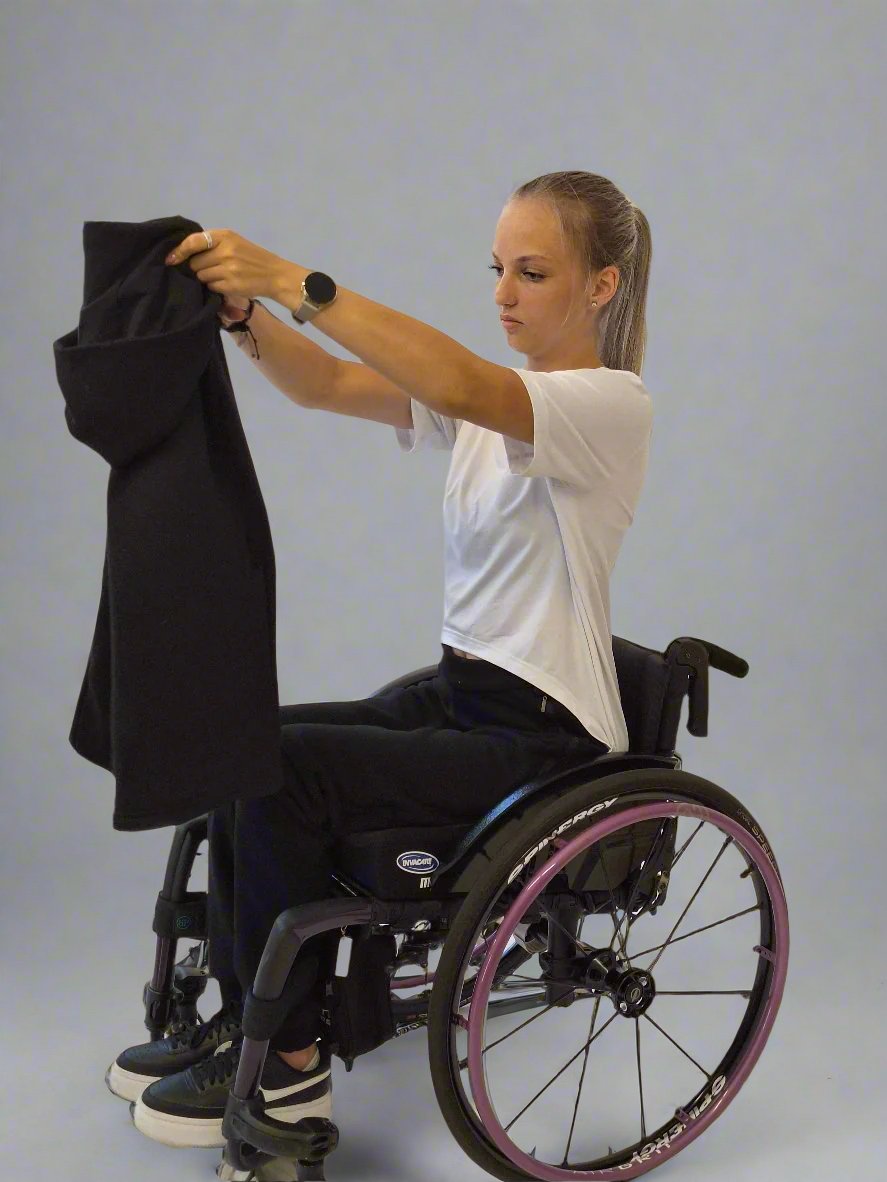 Girl in a wheelchair dressed in Vilber's woman's jersey wheelchair adaptive pants and black jacket