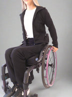 Girl in a wheelchair dressed in Vilber's woman's jersey wheelchair adaptive pants and black jacket
